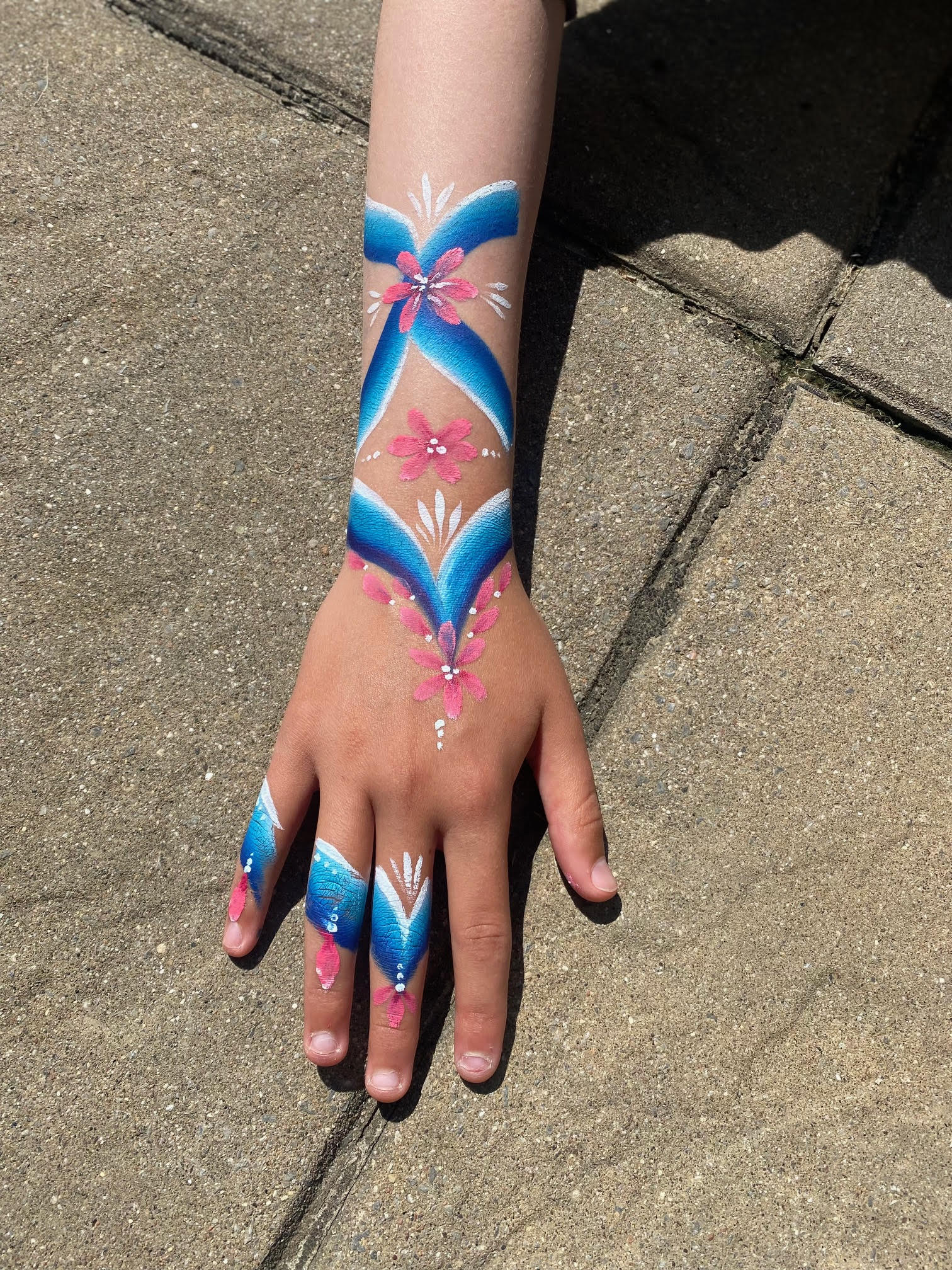 Blue floral arm painting with pink flowers — Flutter Face Paint Ottawa