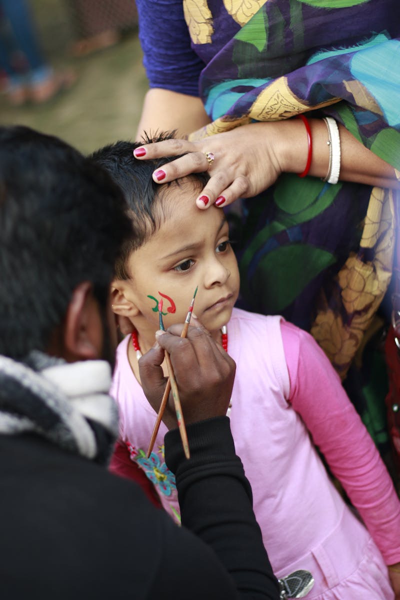 Maryam painting a child's face at a birthday party in Ottawa