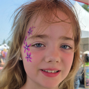 Girl with purple flower face paint by Maryam Fitzgerald — Flutter Face Paint Ottawa